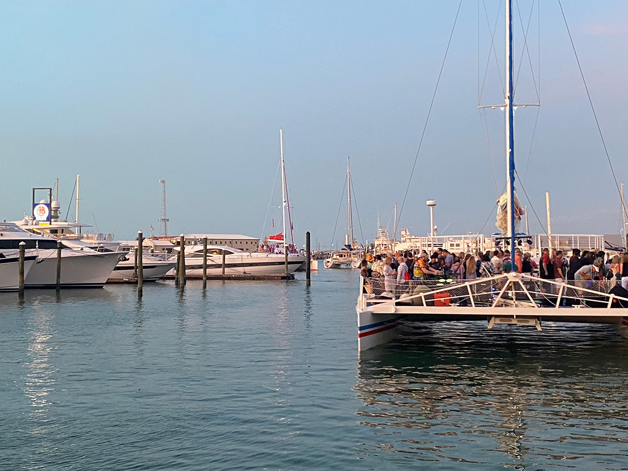 A marina in Key West with a large group of people having fun on a catamaran
