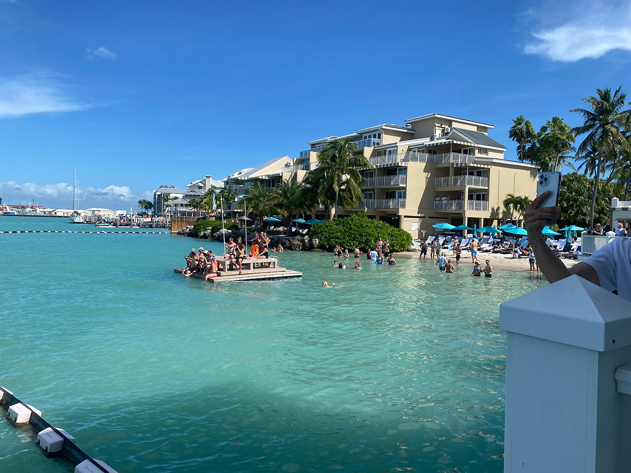 People in Key West swimming at a hotel beach and hanging out on a floating dock